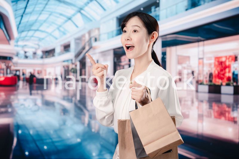 ショッピングモールで福袋を購入する若い女性