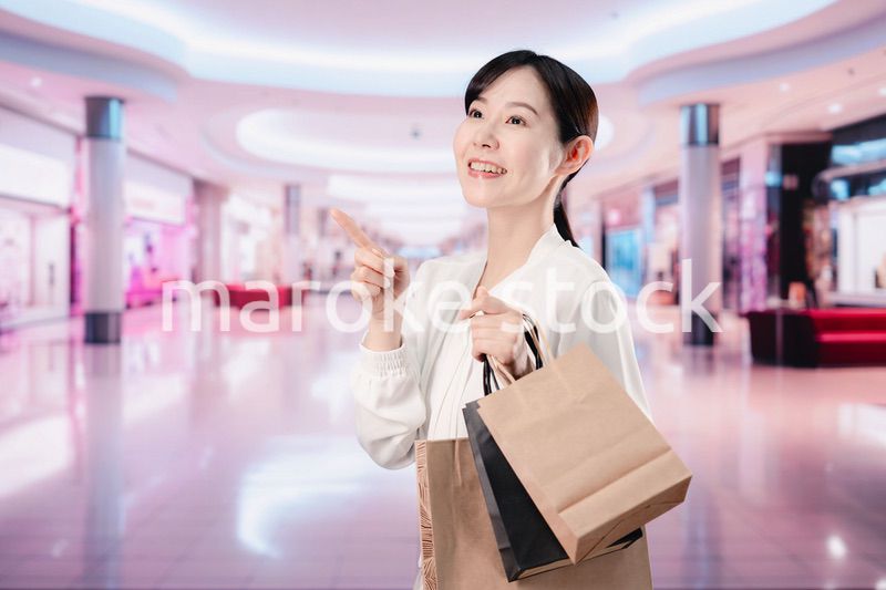 ショッピングモールで福袋を購入する若い女性