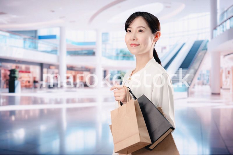 ショッピングモールで福袋を購入する若い女性