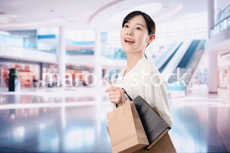 ショッピングモールで福袋を購入する若い女性