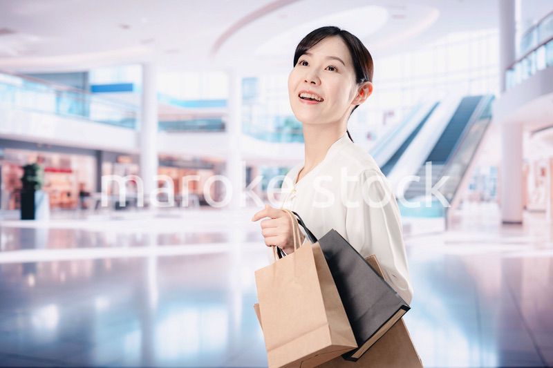 ショッピングモールで福袋を購入する若い女性