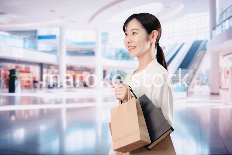 ショッピングモールで福袋を購入する若い女性