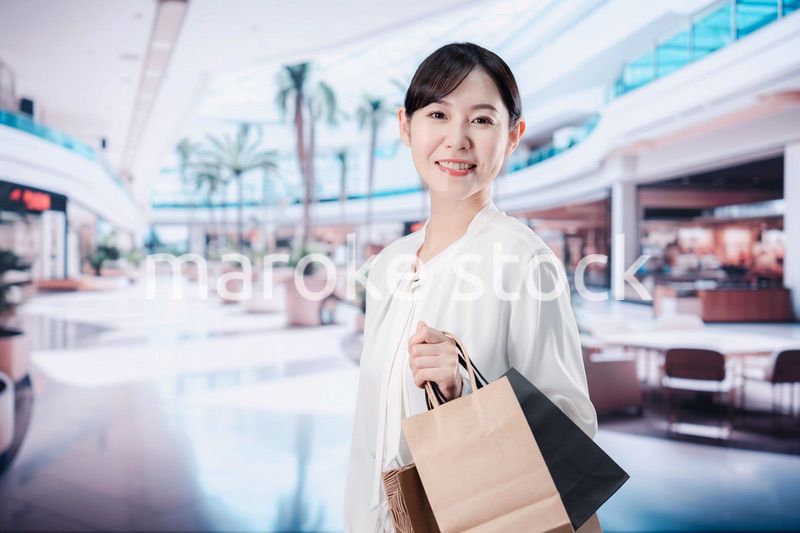 ショッピングモールで福袋を購入する若い女性