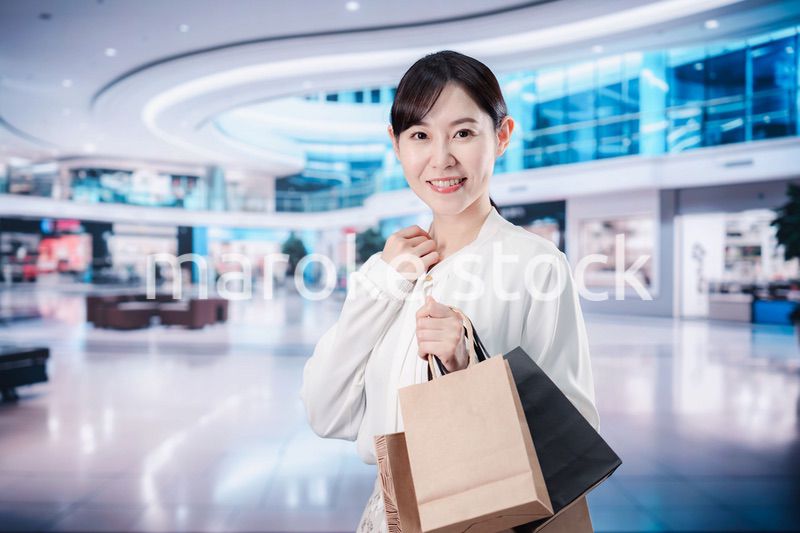 ショッピングモールで福袋を購入する若い女性