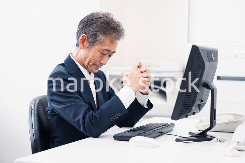 頭を抱えるミドルマネジメントの男性