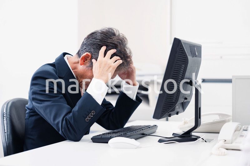 頭を抱えるミドルマネジメントの男性