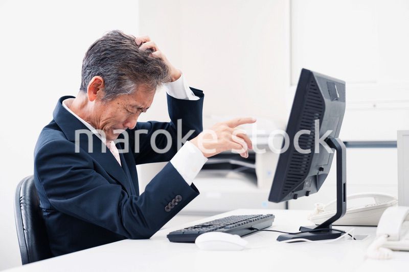 頭を抱えるミドルマネジメントの男性