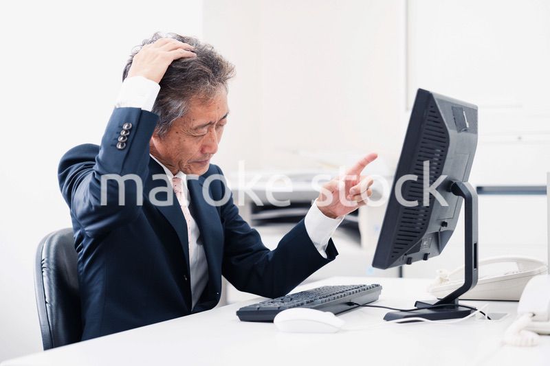 頭を抱えるミドルマネジメントの男性