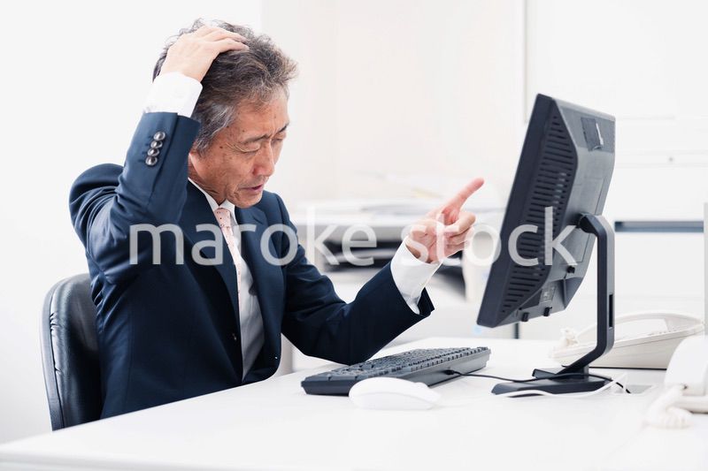 頭を抱えるミドルマネジメントの男性