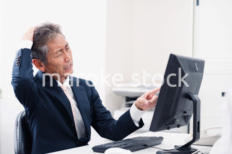 頭を抱えるミドルマネジメントの男性