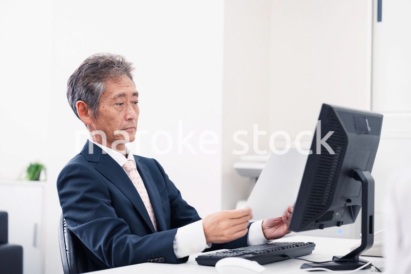 書類を読む中年のビジネスマン