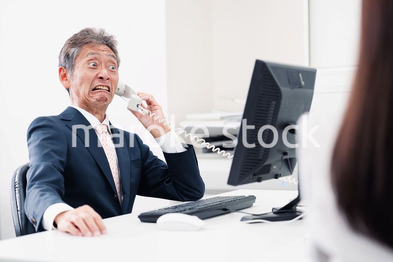 電話で驚く管理職の男性