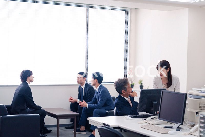 オフィスで上司に報告をするビジネスウーマン
