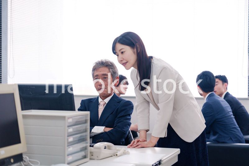 オフィスで上司に報告をするビジネスウーマン