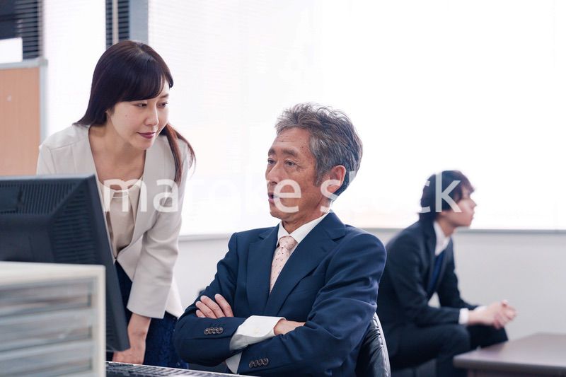 オフィスで上司に報告をするビジネスウーマン