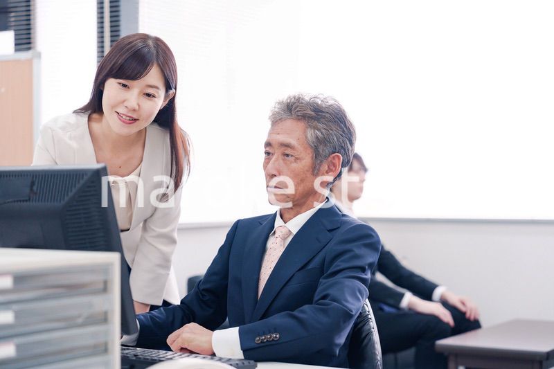 オフィスで上司に報告をするビジネスウーマン