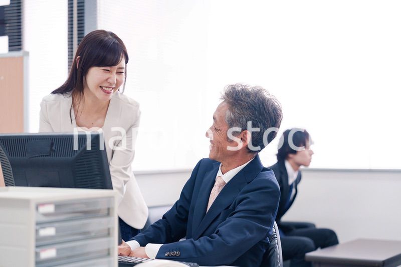 オフィスで上司に報告をするビジネスウーマン