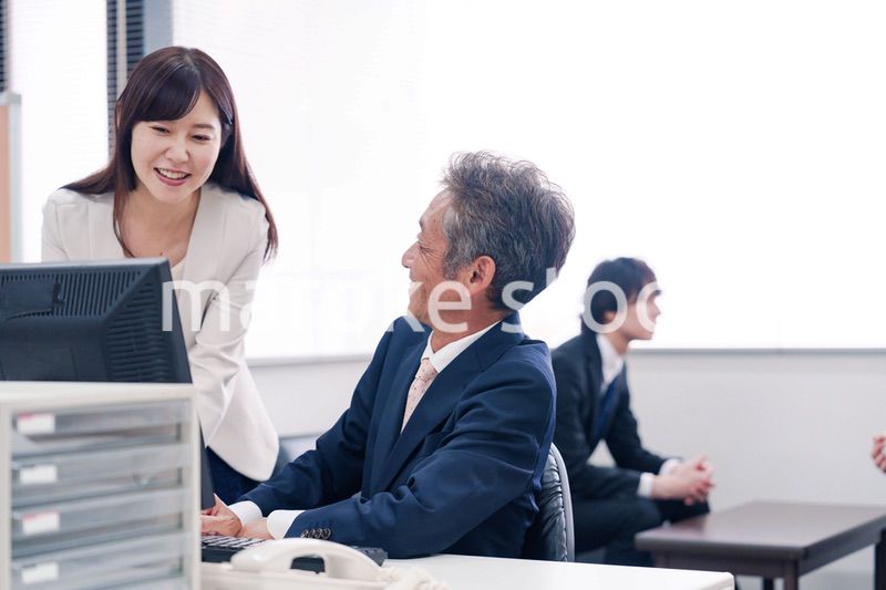 オフィスで上司に報告をするビジネスウーマン