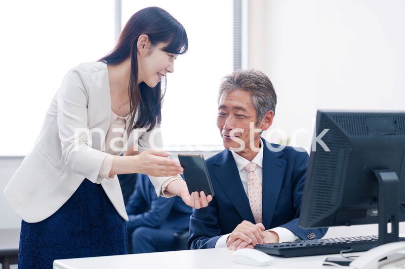 上司にスマホを見せる女性社員