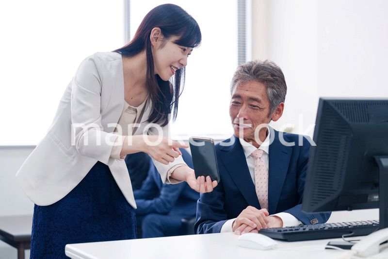 上司にスマホを見せる女性社員