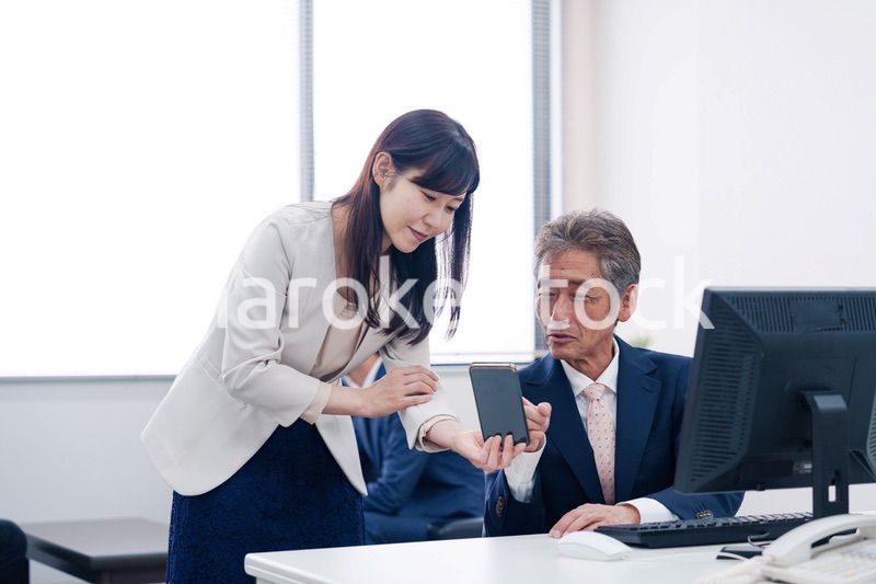 上司にスマホを見せる女性社員
