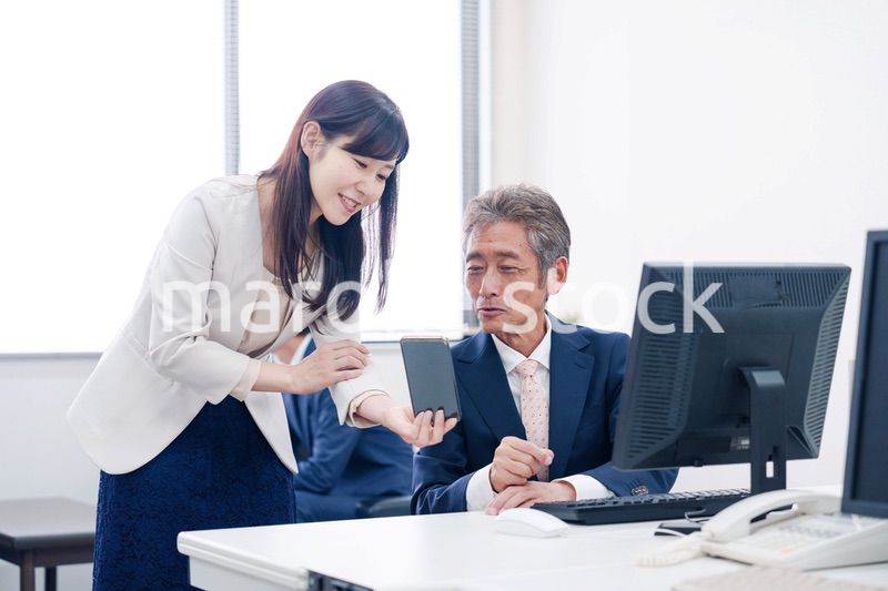 上司にスマホを見せる女性社員