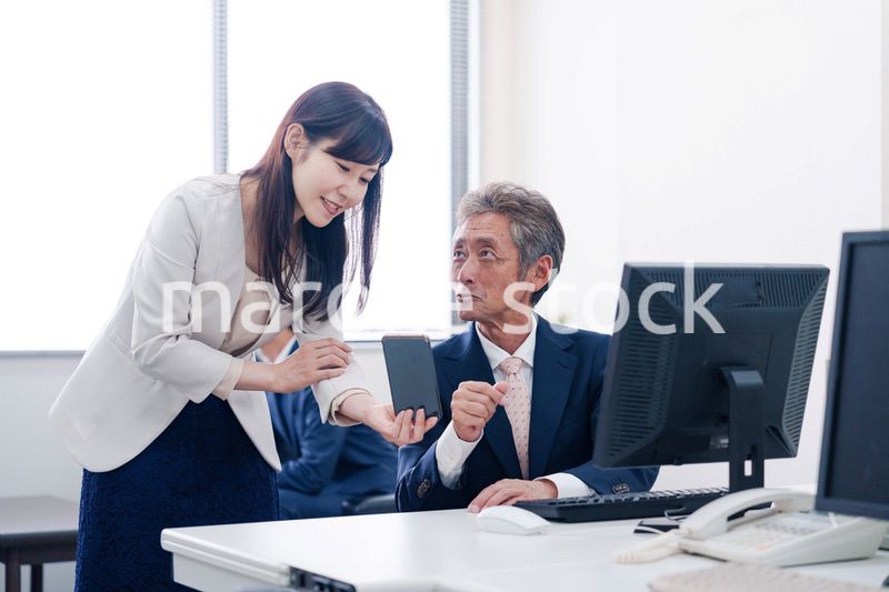 上司にスマホを見せる女性社員