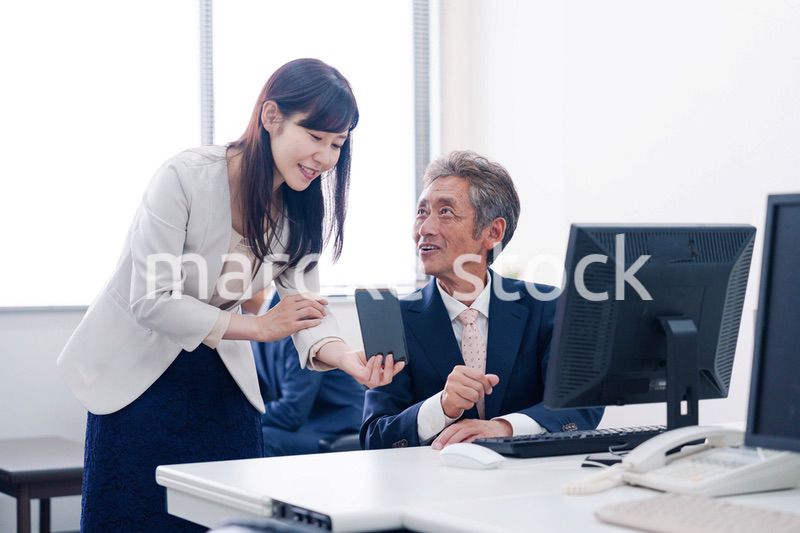 上司にスマホを見せる女性社員