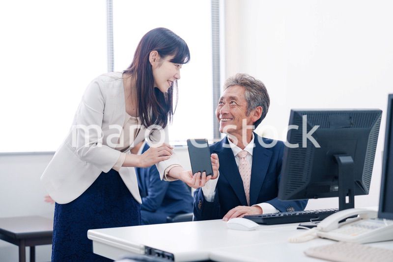 上司にスマホを見せる女性社員