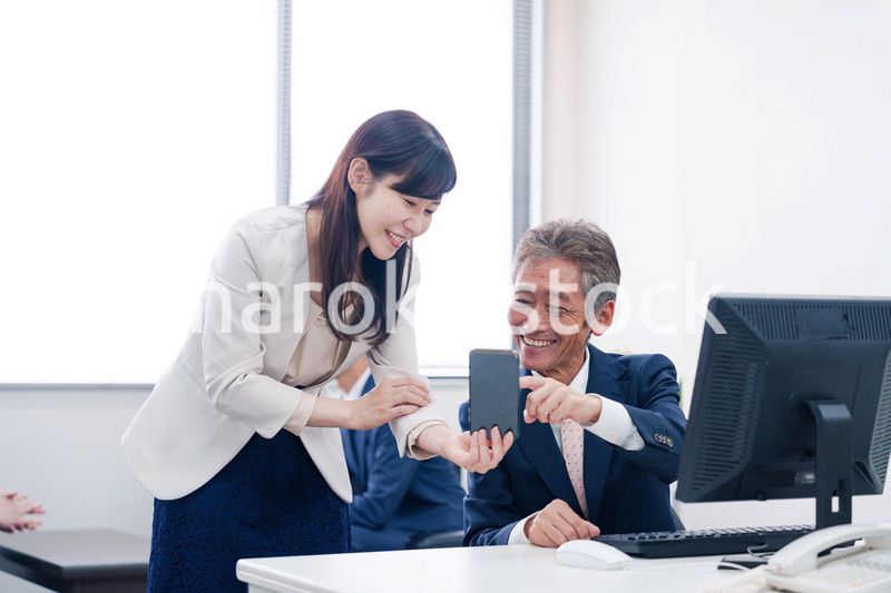 上司にスマホを見せる女性社員