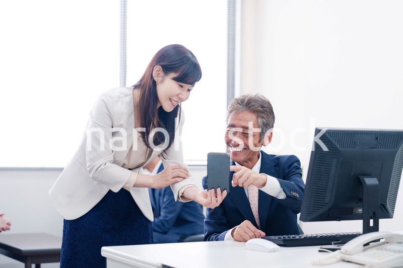 上司にスマホを見せる女性社員