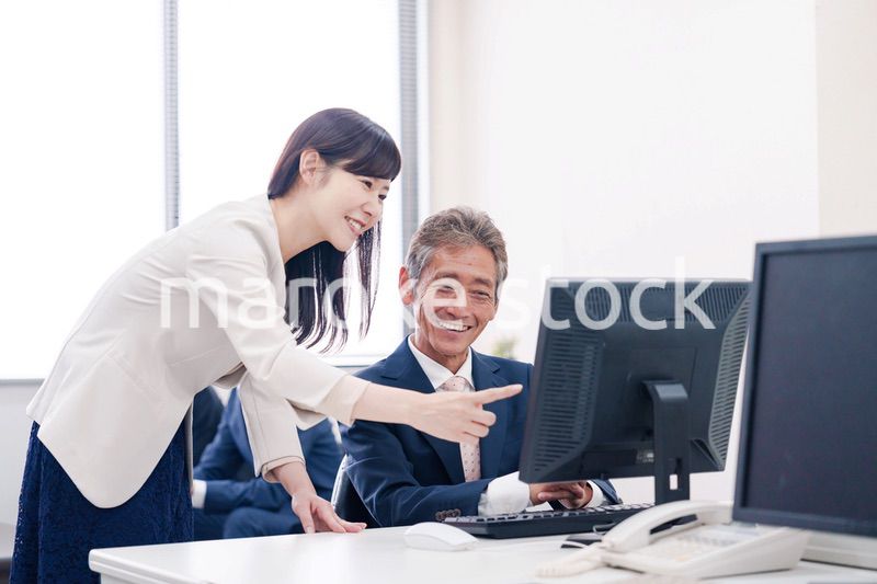 オフィスで上司に報告をするビジネスウーマン