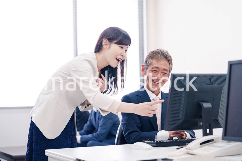 オフィスで上司に報告をするビジネスウーマン