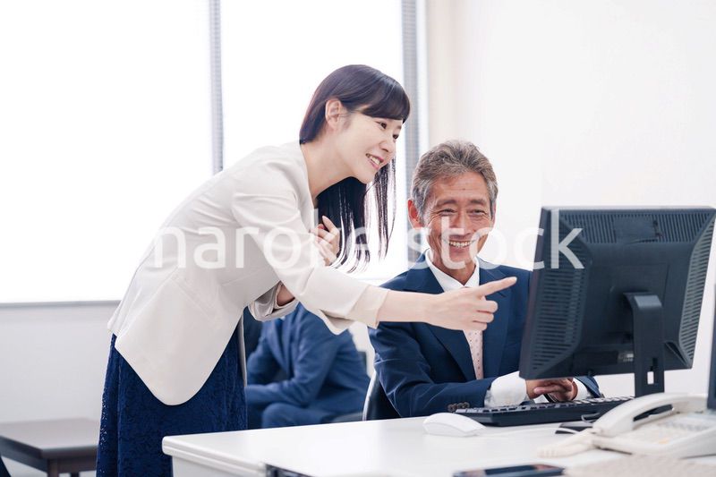 オフィスで上司に報告をするビジネスウーマン