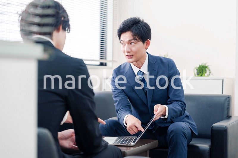 得意先と商談をするスーツを着たビジネスマン