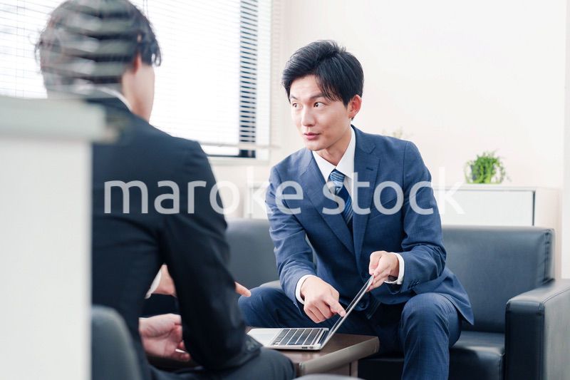 得意先と商談をするスーツを着たビジネスマン