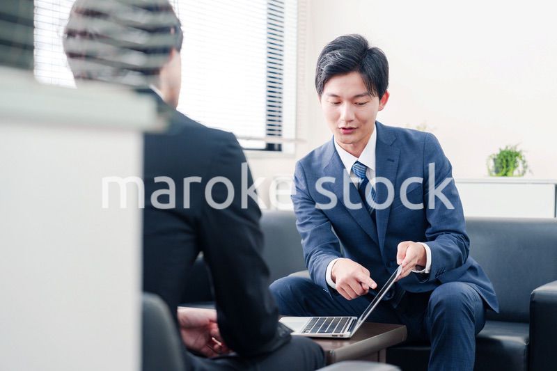 得意先と商談をするスーツを着たビジネスマン