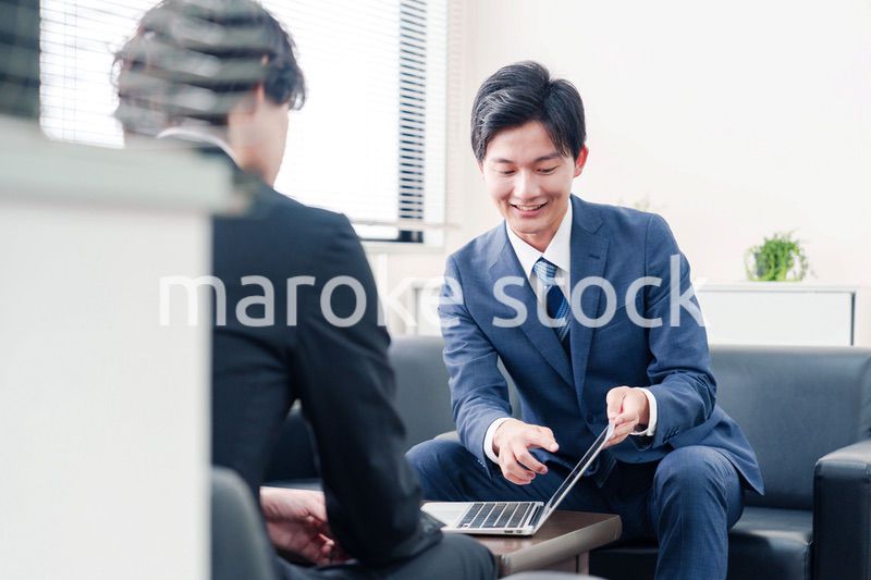 得意先と商談をするスーツを着たビジネスマン