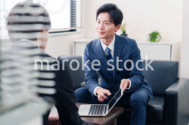 得意先と商談をするスーツを着たビジネスマン