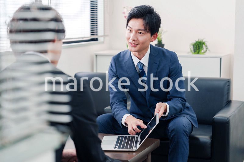 得意先と商談をするスーツを着たビジネスマン