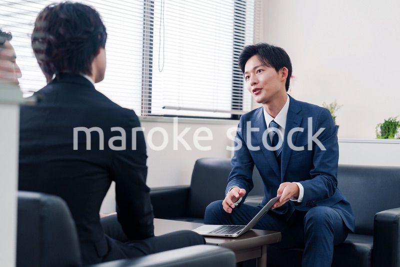 得意先と商談をするスーツを着たビジネスマン