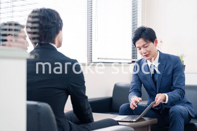 得意先と商談をするスーツを着たビジネスマン
