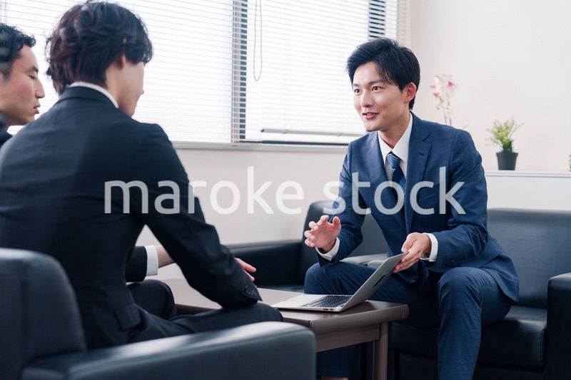 得意先と商談をするスーツを着たビジネスマン
