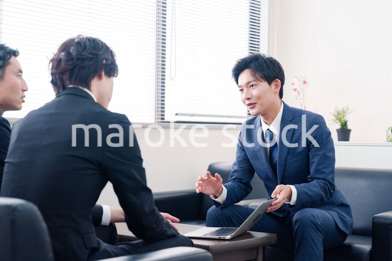 得意先と商談をするスーツを着たビジネスマン