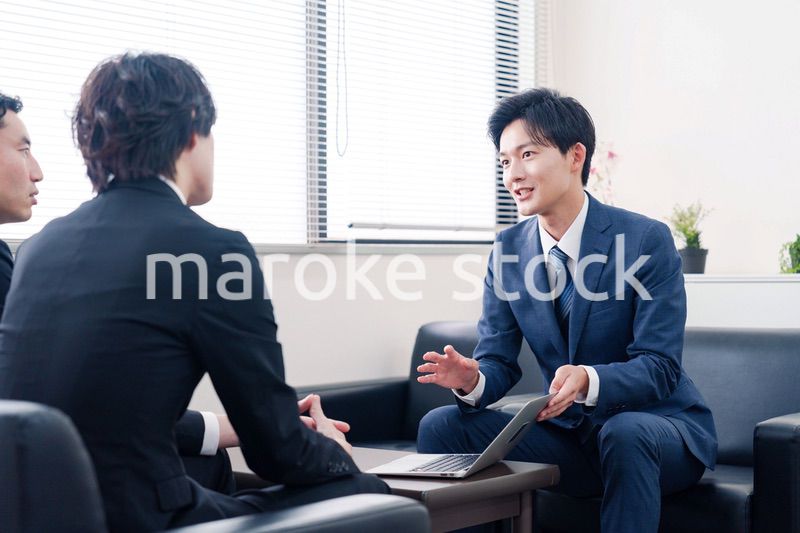 得意先と商談をするスーツを着たビジネスマン