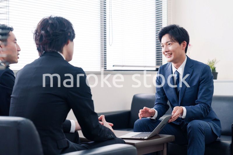 得意先と商談をするスーツを着たビジネスマン
