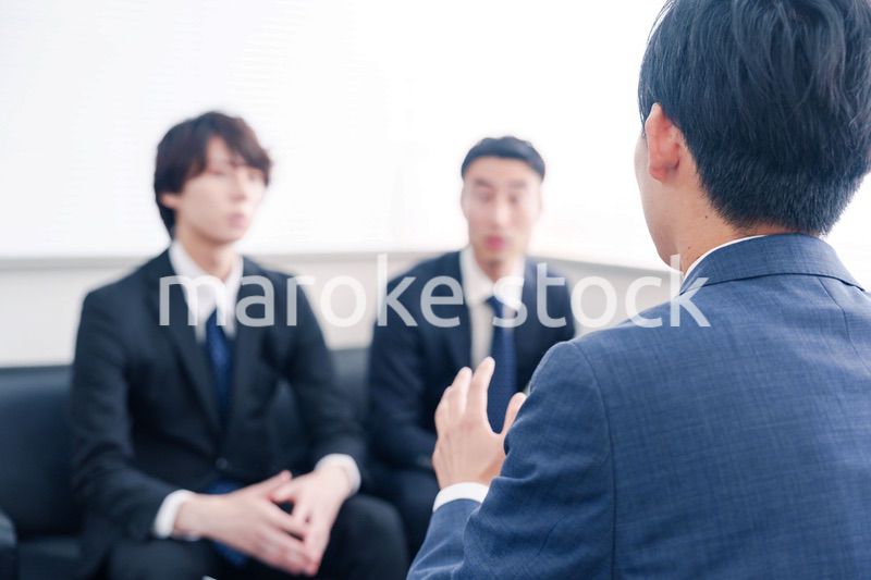 得意先と商談をするスーツを着たビジネスマン
