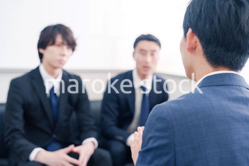 得意先と商談をするスーツを着たビジネスマン