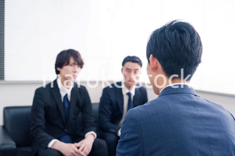 得意先と商談をするスーツを着たビジネスマン