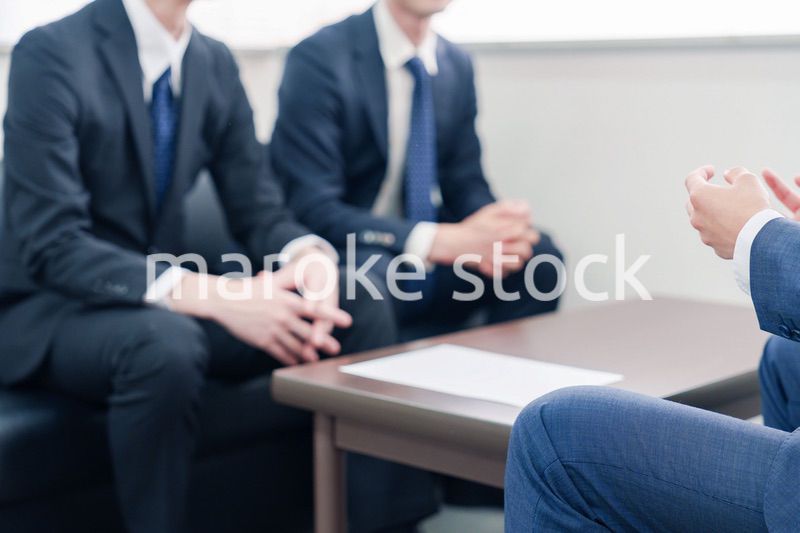 得意先と商談をするスーツを着たビジネスマン